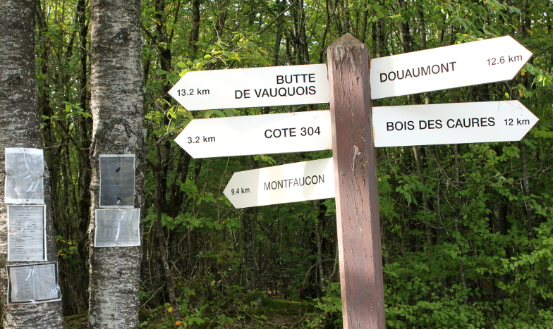 Mort-Homme signpost with distances to Butte de Vauquois, Cote 304, Montfaucon, Douaumont, and Bois des Caures.
Text:
13.2 km Butte de Vauquois
3.2 km Cote 304
9.4 km Montfaucon
Douaumont 12.6 km
Bois des Caures 12 km