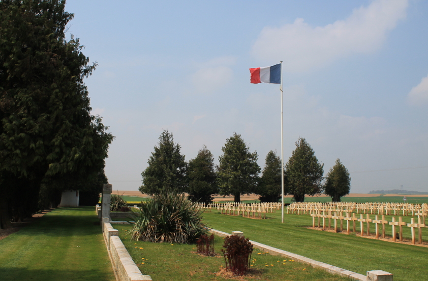 The French flag, ossuaries, and headstones, Biaches Military Cemetery on the Somme.