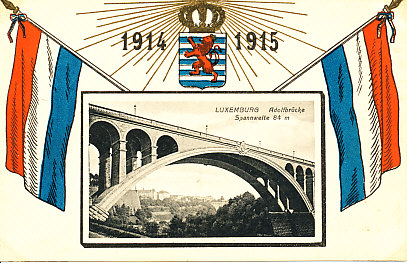 Above a black and white photograph of the Adolf Bridge (span: 84 meters)is the shield of Luxemburg, a red lion rampant on a background of blue and white horizontal stripes. Above the shield is a radiating crown and the years 1914 and 1915. The flag of Luxemburg - three horizontal bars of red, white, blue - is on either side.