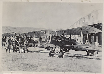 British pilots and ground crew with three S.E.5-A fighters in front of their hangars. The plane in the foreground has its engine running.
Text, reverse:
Pencil: S.E.5A; stamped: 29