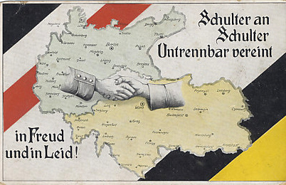 Zweibund — the Dual Alliance — Germany and Austria-Hungary united, were the core of the Central Powers, and here join hands. The bars of Germany's flag border the top left, and those of the Habsburg Austrian Empire and ruling house the bottom right.
Text:
Schulter an Schulter
Untrennbar vereint
in Freud und in Leid!'

Shoulder to shoulder
Inseparably united 
in joy and in sorrow!