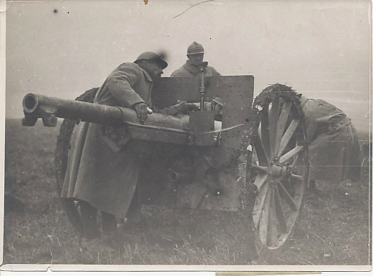 A French artillery crew moving a 75mm. field gun into position in Bougainville, France, behind the lines, west of Amiens. Bougainville is a commune in the Somme Département in Picardie. The Adrian helmet the soldiers wear was introduced in mid-1915.
Text, Reverse:
Bougainville / Somme
mise en batterie d'une 75
deploying a 75