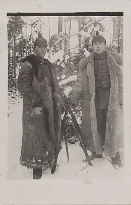 Photograph of two German soldiers in spiked helmets and fur coats, standing in snow woods, holding their rifles with bare hands, dated January 24, 1918. A short translation from the reverse: “. . . The Russians are already gone. They are right. We should do the same . . . " (translation, Thomas Faust).