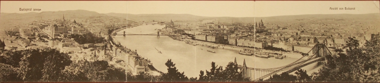Panoramic view of Budapest on the Danube River. The hill(s) of Buda are on the left, and Pest is on the right. Prominent buildings include Parliament and St. Stephen's Cathedral.
Text:
Budapest látképe
Ansicht von Budapest
View of Budapest