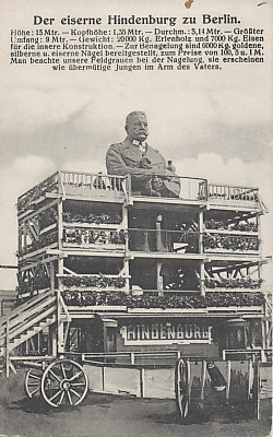 The massive Iron Hindenburg in Berlin, its decorative scaffolding and cannons. One method to raise war funds was through nailings, charging for adding a nail to a wooden iron cross, statue or other object. Berlin was the site of this massive statue of General Paul von Hindenburg, hero of the Battle of Tannenberg. One could nail an iron, silver, or gold nail for 1, 5, or 100 marks respectively.
Text:
Der eiserne Hindenburg zu Berlin
Höhe: 13 Mtr. - Kopfhöhe: 1,35 Mtr. - Durchm.: 3,14 Mtr. - Größter Umfang: 9 Mtr. - Gewicht: 20000 Kg. Erlenholz und 7000 Kg. Eisen für die innere Konstruktion. - Zur Benagelung sind 6000 Kg. goldene, silberne u. eiserne Nägel bereitgestellt, zum Preise von 100, 5 u. 1 M. Man beachte unsere Feldgrauen bei der Nagelung, sie erscheinen wie übermütige Jungen im Arm des Vaters.

The Iron Hindenburg in Berlin
Height: 13 meters - Head Height: 1.35 meters - Dia. 3.14 meters - Greatest Extent: 9 meters - Weight: 20,000 Kg., 7,000 Kg. alder wood and iron for the inner construction. - 6,000 Kg. of gold, silver and iron nails are available for nailing, at the price of 100, 5 and 1 Mark. Note our troops in field gray who are nailing; they seem like wanton boys in their father's arm.

Reverse:
Dated and postmarked May 19, 1916 from Berlin.