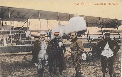 French pilot and officers in front of a Farman pusher biplane at an airfield in Salonica, Greece. Note the windscreen. Other planes and grounds crew can be seen in the background. The message on the reverse is dated February 28, 1917.
